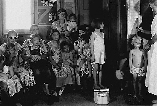 Photograph of Arvin Camp parents with children, who are having height and weight measured, 09/1936, courtesy of the US National Archives.